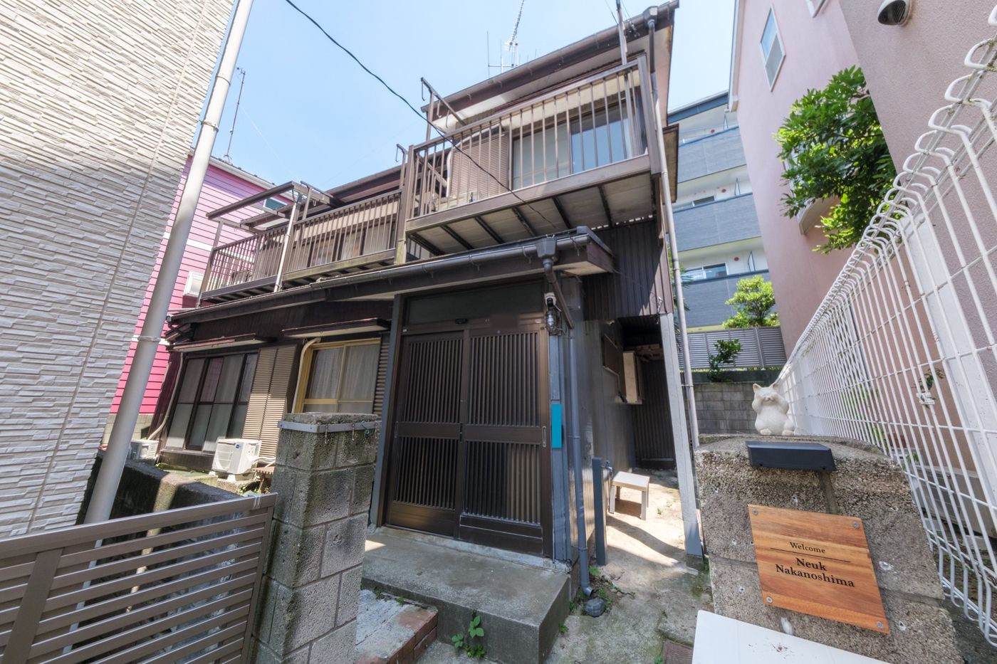 二階建ての古民家の外観。門柱に Neuk Nakanoshima の木の看板
